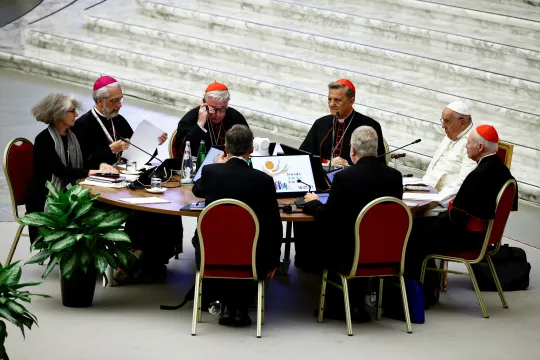 Pave Frans sitter ved bordet med deltakere under synoden om synodalitet i Vatikanet