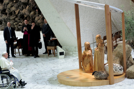 Pave Frans sitter foran en julekrybbe med figurer av Maria og Josef i Paul VI-salen i Vatikanet