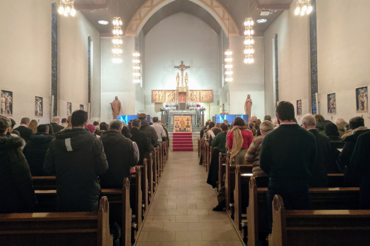 Troende ser på biskop Fredrik Hansens bispevielse på store skjermer i St. Joseph kirke