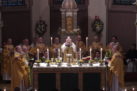 Biskop Fredrik Hansen løfter hostien over alteret under en messe i St. Olav domkirke