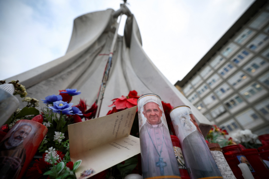 Blomster og lys med bilder av pave Frans utenfor Gemelli-sykehuset i Roma