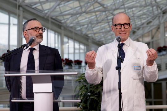 To menn, en i dress og en i legefrakk, holder pressekonferanse på Gemelli-sykehuset i Roma