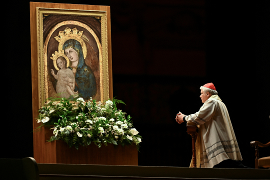En kardinal ber knelende foran et ikon av Jomfru Maria og Jesus på Petersplassen