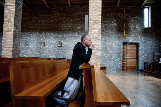 Biskop Erik Varden ber i en kirkebenk i St. Olav domkirke i Trondheim