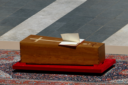 Sidene i evangelieboken på pave Frans' kiste blafrer i vinden