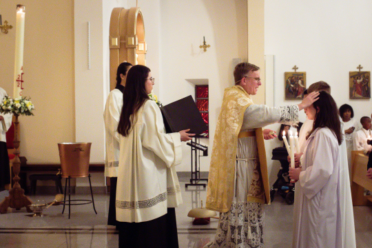 P. Pål Bratbak, ikledd messeklær, velsigner troende i St. Svithun kirke