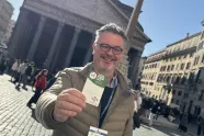 Hans Rossiné holder opp et nordisk pilegrimskort mens han står foran Panteon i Roma