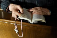 Hender holder en rosenkrans og en bibel med kinesisk skrift