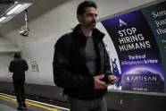 En mann går forbi en reklame på undergrunnen i London
