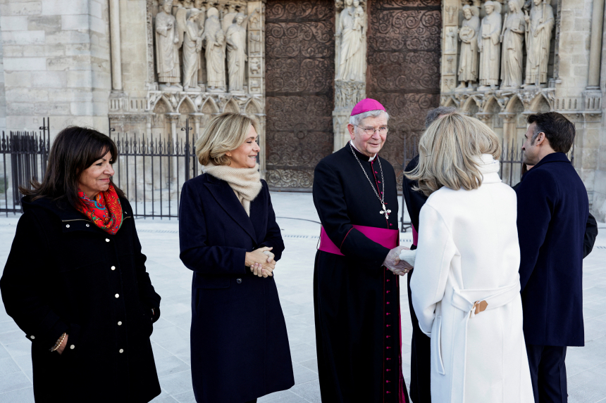 Paris' erkebiskop Laurent Ulrich hilser på Frankrikes førstedame Brigitte Macron utenfor Notre-Dame de Paris.