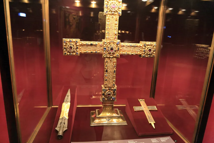 Spissen på en lanse ved siden av et stort forgylt kors i en glassmonter