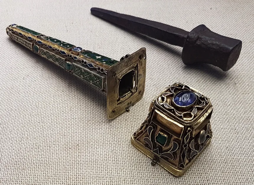 sort nagle av metall ved siden av relikvarium med edelstener