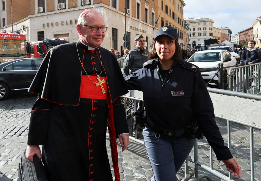 Kardinal Eijk går ved siden av en politikvinne på gaten i Roma