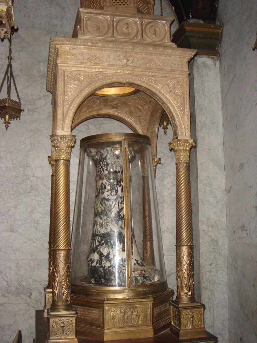 En marmorsøyle i en glassbeholder under et tak inne i en kirke