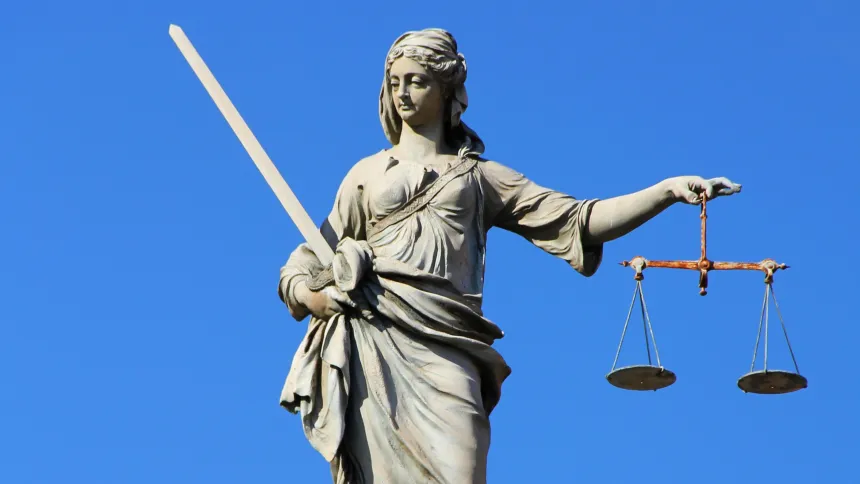 En statue av Fru Justitia med vektskåler og sverd i hånden