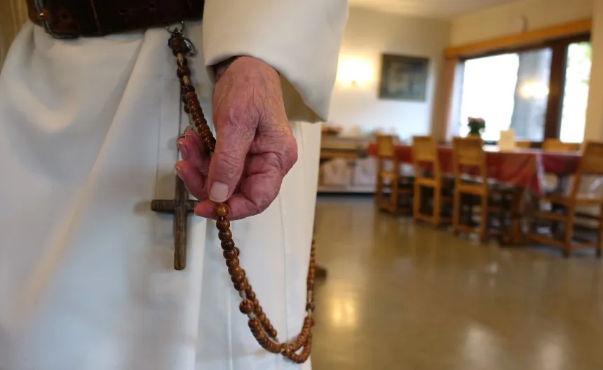 Mann i dominikanerdrakt holder en rosenkrans