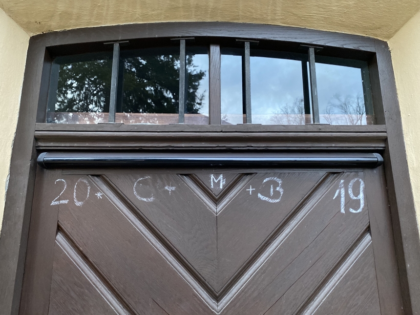 En ytterdør med tegnene 20+C+M+B+19 skrevet i kritt