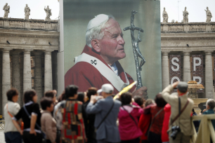 Pilegrimer foran et stort bilde av pave Johannes Paul II på Petersplassen
